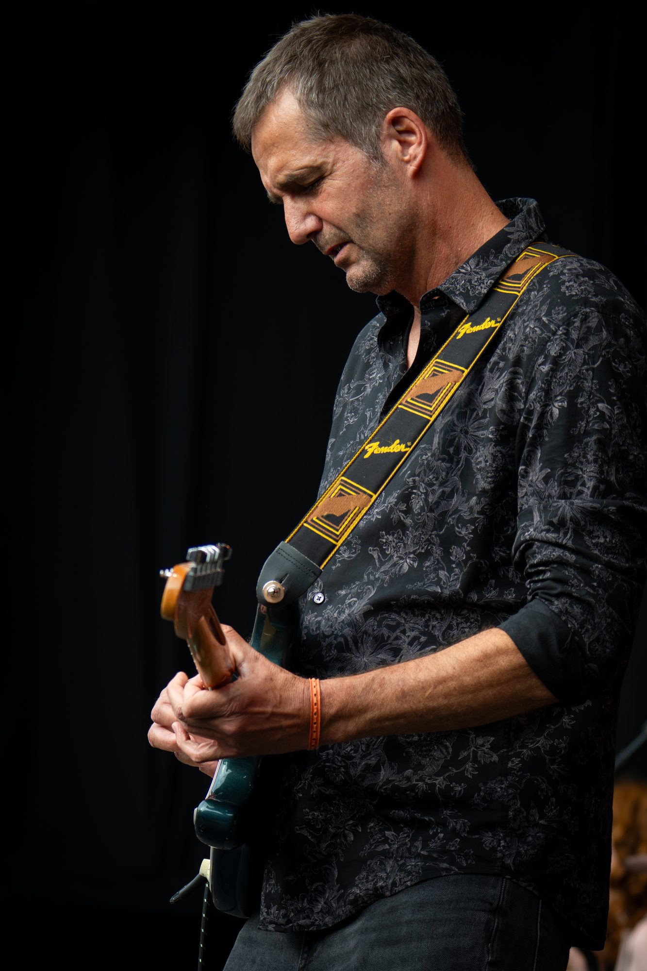 Jochen Probst mit Fender Stratocaster auf der Festivalbühne, schwarzer Hintergrund